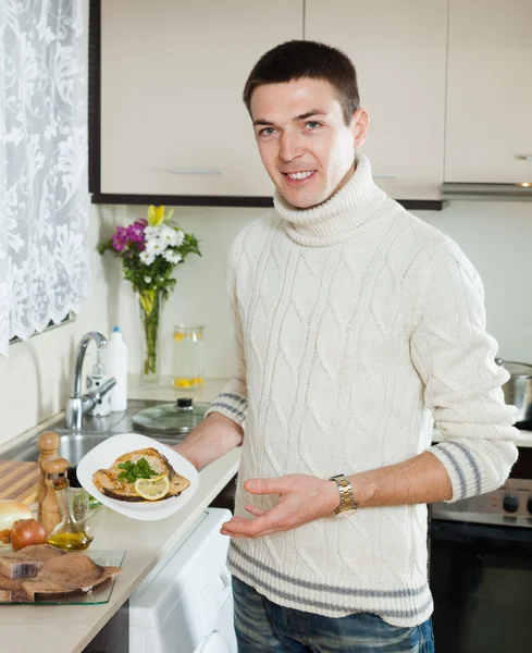 Glimlachende man met gekookte vis biefstuk — Stockfoto