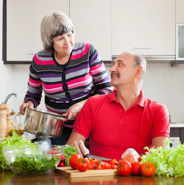 Loving mature couple cooking in kitchen — Stock Photo, Image