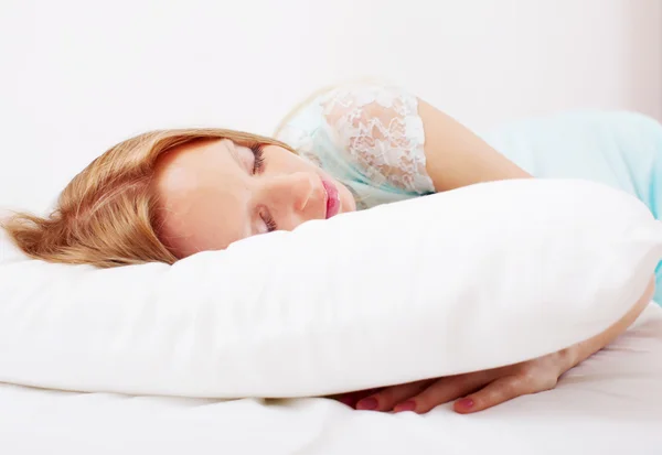 Kvinna i nattskjorta sova på vit kudde — Stockfoto