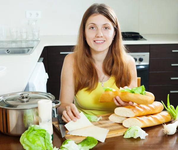 Donna felice cucina panini con formaggio — Foto Stock