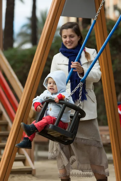 Mother with toddler on swings — Stock Photo, Image