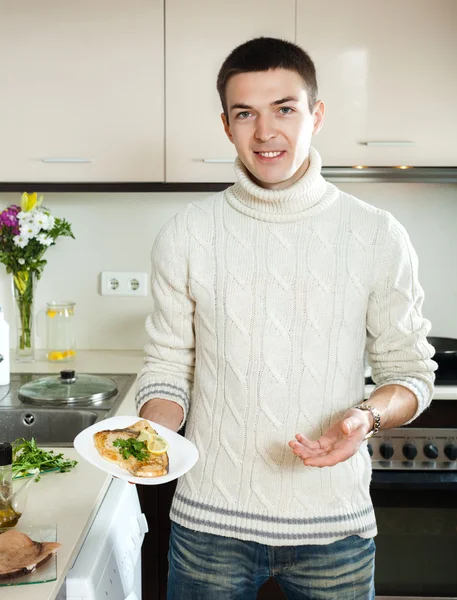 Ragazzo con bistecca di pesce sul piatto a casa cucina — Foto Stock