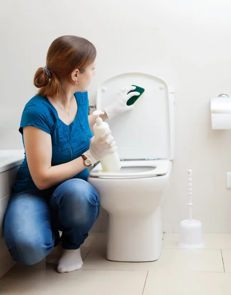 Dona de casa em azul limpeza vaso sanitário — Fotografia de Stock