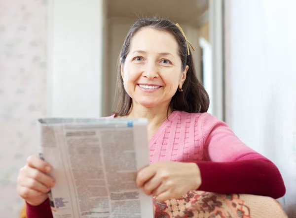 Mature woman reads newspaper — Stock Photo, Image