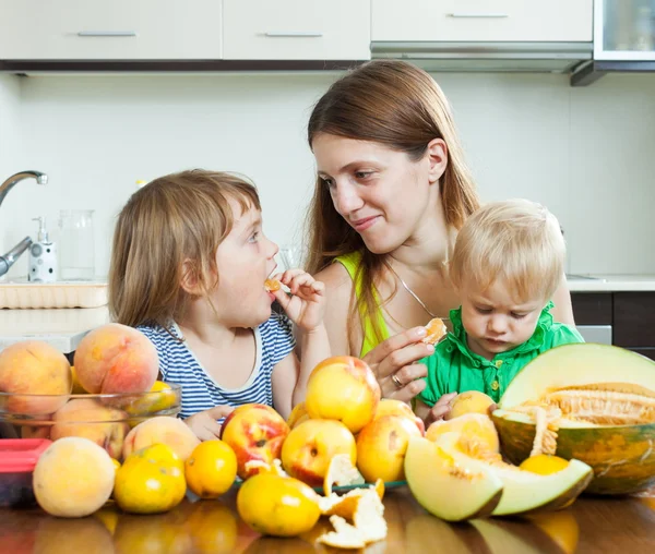 Woman with daughters eating melon — Stock Photo, Image