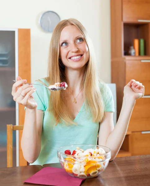 Pretty long-haired woman eating fruit salad with yoghurt — Stock Photo, Image