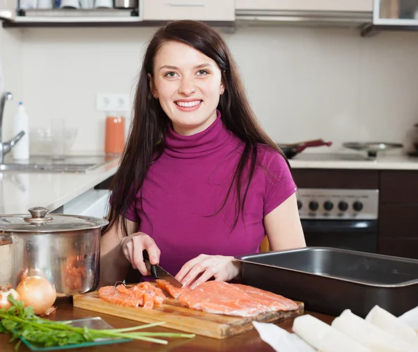 Glückliche Frau schneidet Lachs für Fischkuchen — Stockfoto