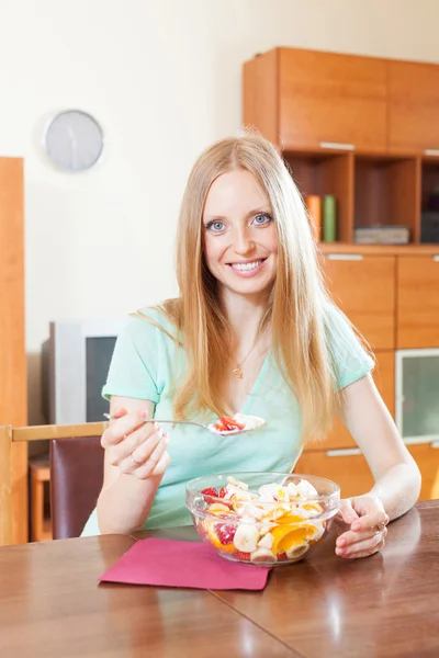 Långhåriga kvinna äta fruktsallad med yoghurt — Stockfoto