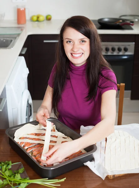 Mulher feliz cozinhar torta de peixe — Fotografia de Stock