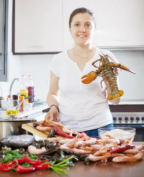 Jeune femme cuisine des produits marins — Photo