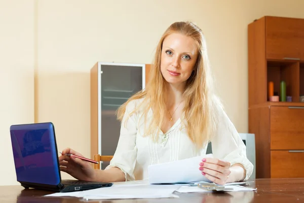 Weemoedig blonde vrouw werken met financiële documenten — Stockfoto