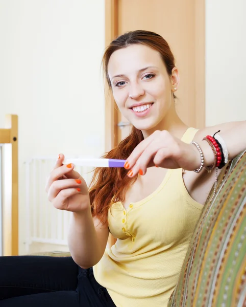 Улыбающаяся девушка с тестом на беременность — стоковое фото