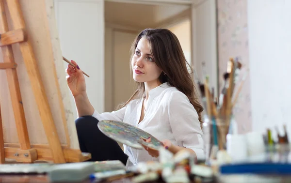 Woman paints picture on canvas in her studio — Stock Photo, Image