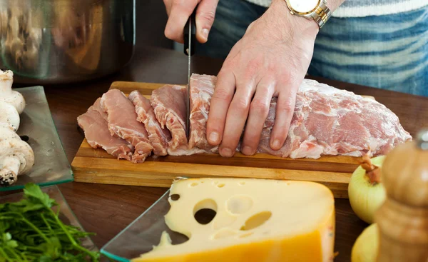 Hände schneiden rohes Fleisch — Stockfoto