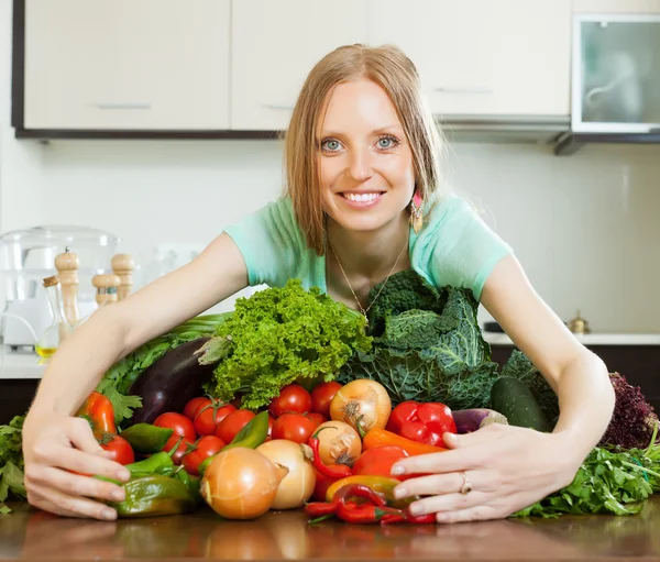 Portrait of happy woman with heap of vegetables — Stock Photo, Image