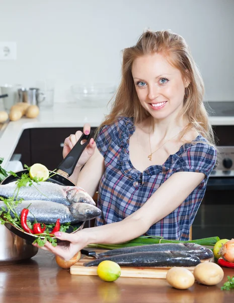 Leende flicka med rå havsabborre fisk — Stockfoto