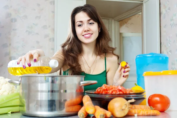 Jeune femme au foyer cuisinier avec de l'huile — Photo