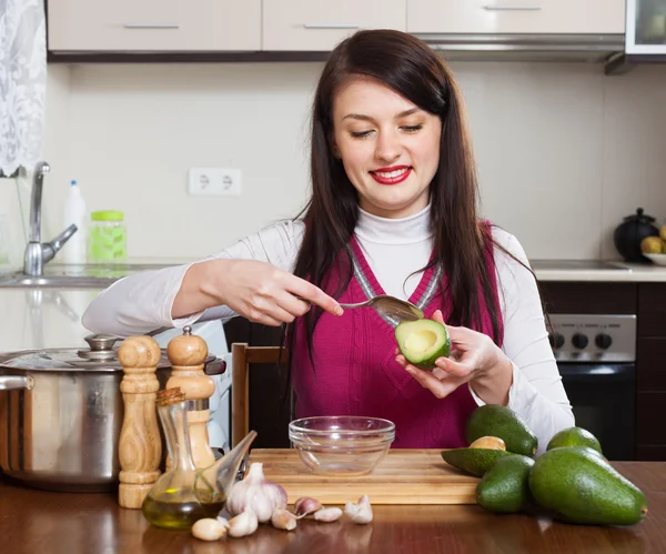 Gelukkige huisvrouw koken met avocado — Stockfoto