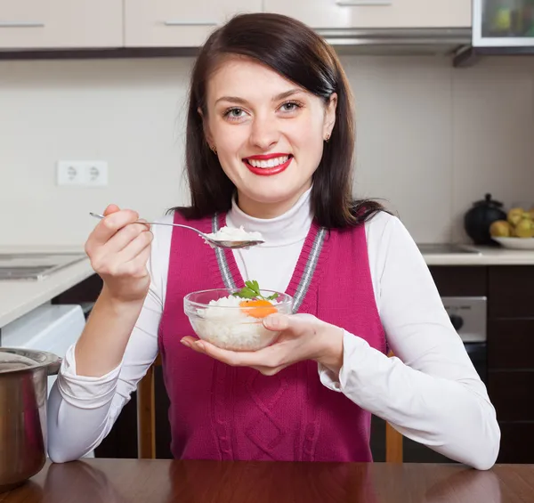 Femme brune souriante mangeant du riz bouilli — Photo