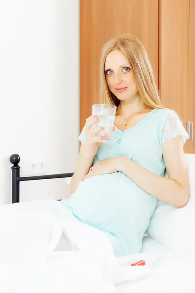 Graviditet kvinnan med glas vatten — Stockfoto