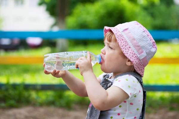 Child drinks from plastic bottle — Stock Photo, Image