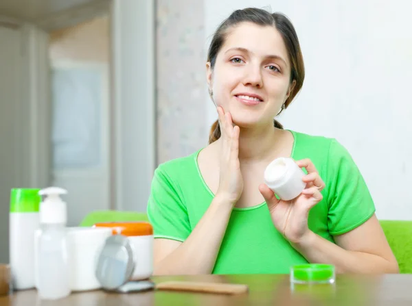 Woman in green caring for her face — Stock Photo, Image