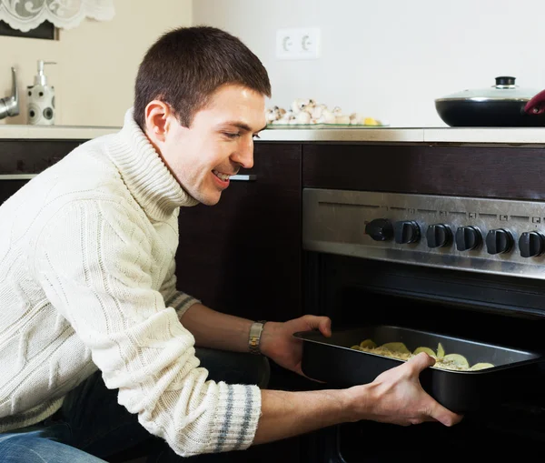 Хлопець смажить м'ясо в духовці — стокове фото