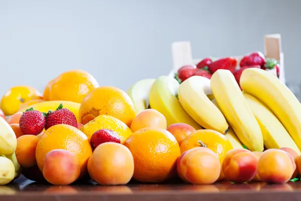 Various fruits at table in kitchen — Stock Photo, Image