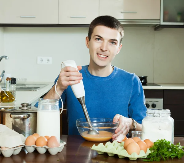 Chico cocinando huevos revueltos para el desayuno —  Fotos de Stock