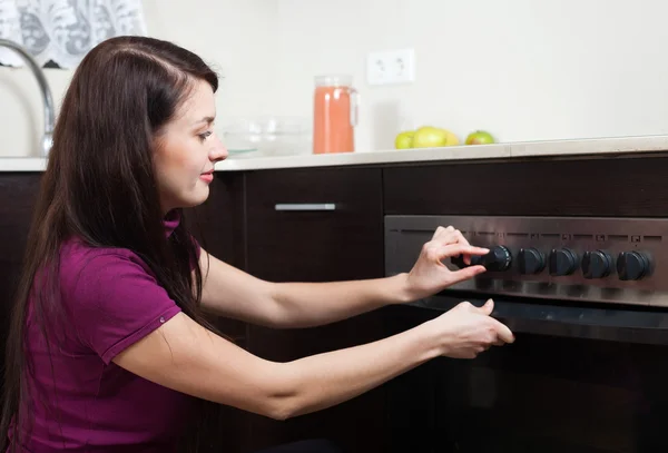 Woman cooking something in the oven — Stock Photo, Image