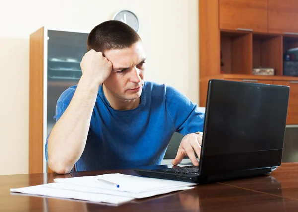 Trauriger verwirrter Mann blickt auf Laptop — Stockfoto