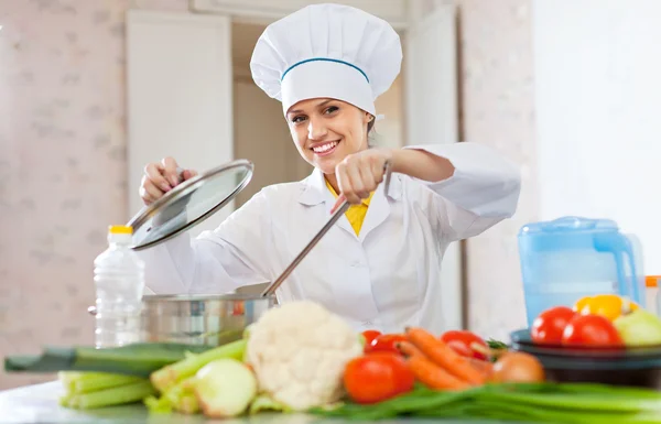 Cook in uniform works with vegetables — Stock Photo, Image