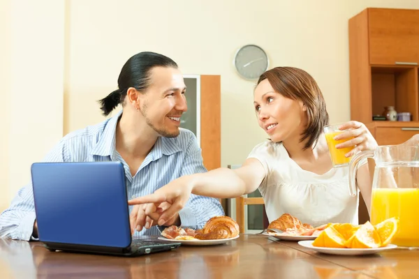 Pareja buscando e-mail en el ordenador portátil durante el desayuno — Foto de Stock