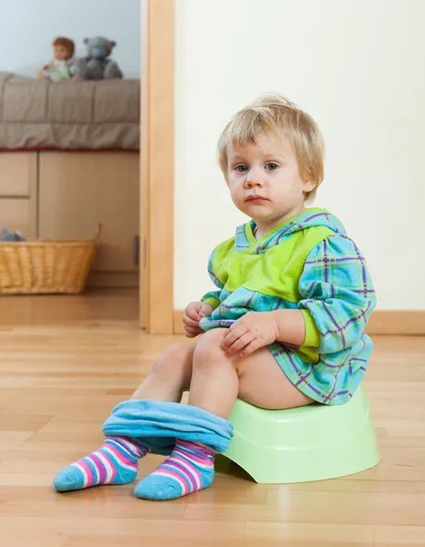 Kleinkind sitzt auf grünem Töpfchen — Stockfoto