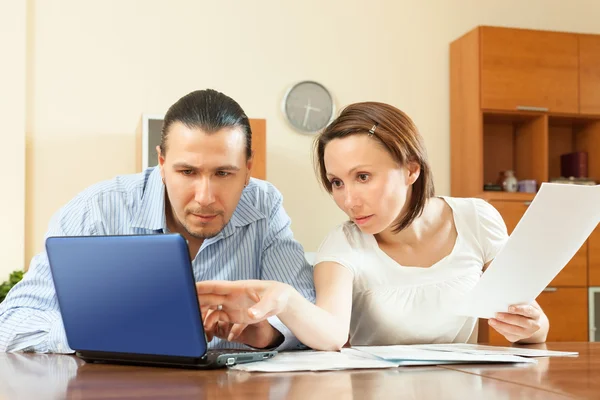 Casal olhando documentos financeiros à mesa — Fotografia de Stock