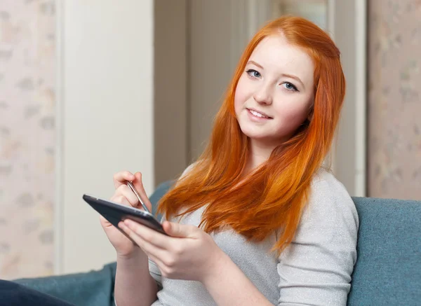 Adolescente menina lê tablet computador em casa — Fotografia de Stock