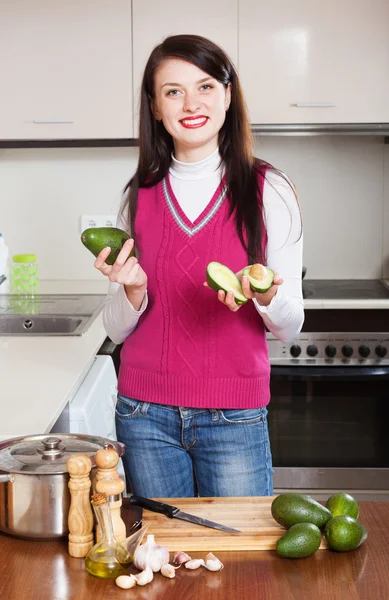 Flicka med avokado i köket — Stockfoto