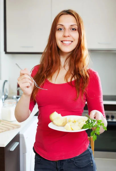 Mujer ordinaria positiva comiendo papa — Foto de Stock