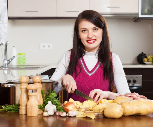 Mutlu bir kadın patates pişirme — Stok fotoğraf