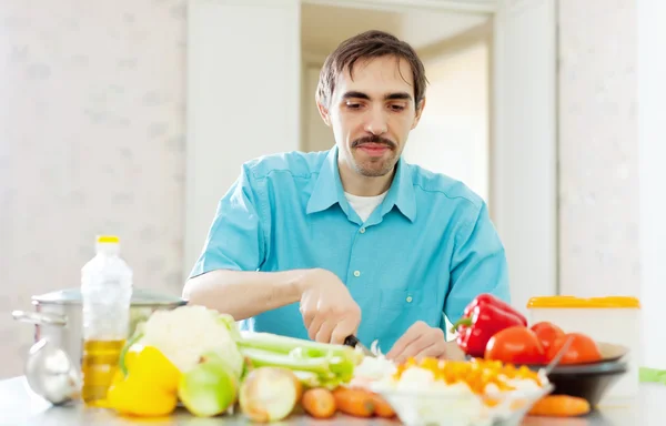 Adam evde sebze yemek — Stok fotoğraf