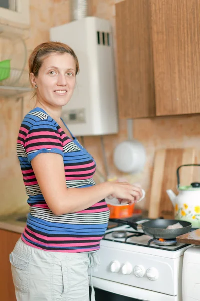 Femme enceinte cuisine des aliments — Photo