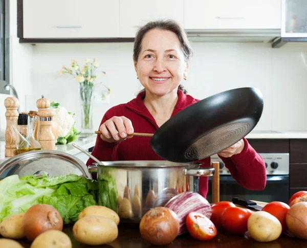 Mulher madura feliz cozinhar com frigideira — Fotografia de Stock