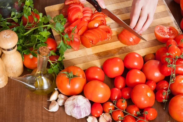 Großaufnahme weiblicher Hände beim Tomatenschneiden — Stockfoto