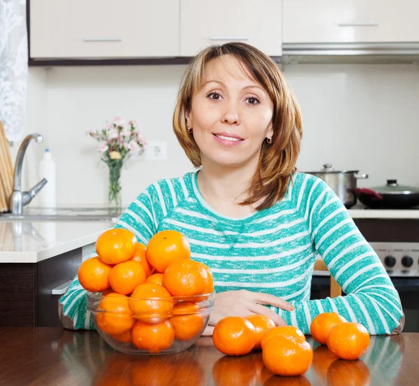 Femme au foyer en vert avec des mandarines — Photo