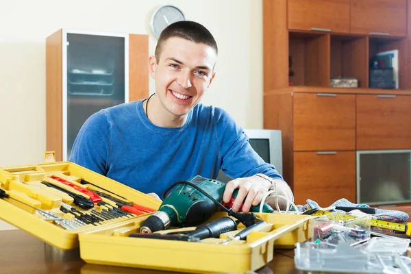 Happy sorrindo cara organiza ferramentas na mesa — Fotografia de Stock