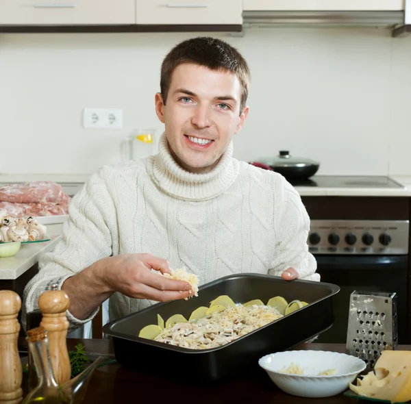 Guy cooking meat in kitchen — Stock Photo, Image