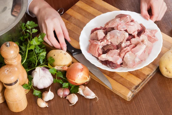 Mani femminili con carne e patate — Foto Stock