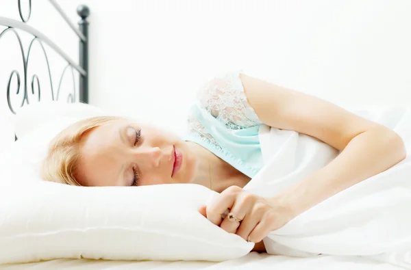 Mujer durmiendo en sábana blanca — Foto de Stock