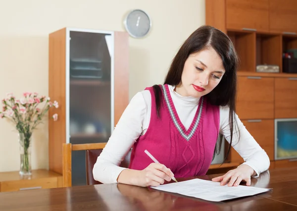 Mujer seria rellenando documentos financieros — Foto de Stock