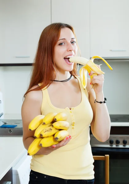 Long-haired girl eating banana — Stock Photo, Image